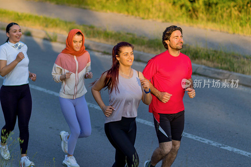 一群健康的人在城市公园慢跑，跑步团队在晨练。一群年轻人在公园里训练