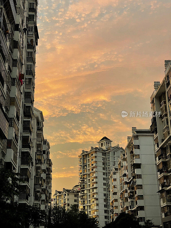 天空的日落与城市住宅建筑的低视图