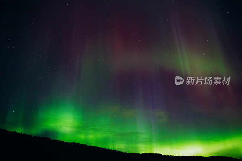 挪威山脉上空的强烈北极光