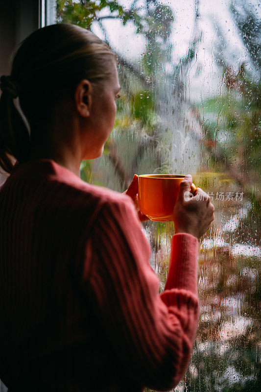 雨天在窗前喝咖啡的女人