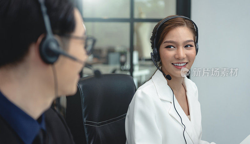 亚洲呼叫中心代理团队，客户服务支持戴着耳机或耳机与客户在现代化的办公室交谈。