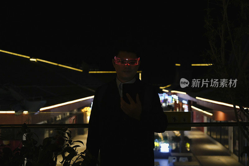 一名戴着智能眼镜的男子在夜间使用手机