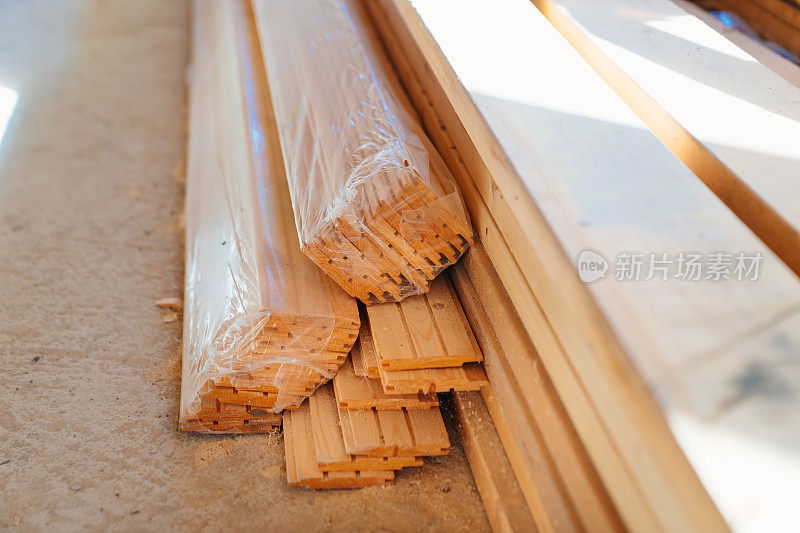 在一栋在建的木屋里，木梁堆放在地板上。