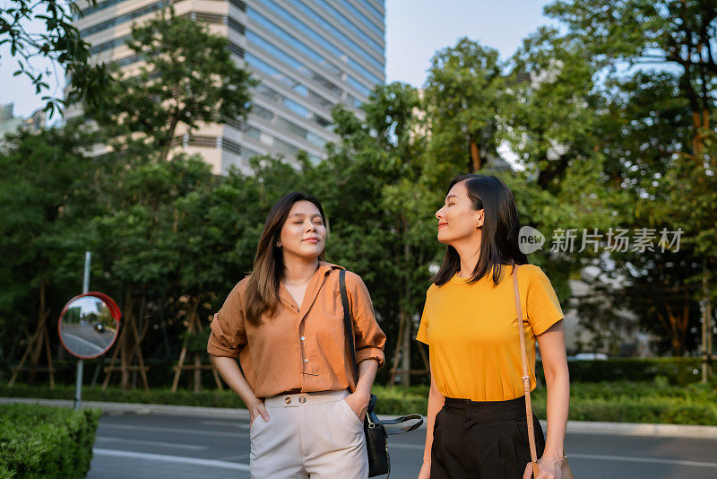 两个亚洲女人在下班回家的路上一起享受黄金时间。