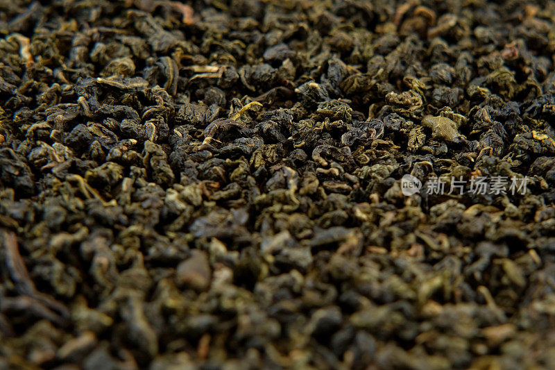 散装茶叶。黑色干茶壁纸。混合红茶和绿茶。特写，微距。前视图。纹理。完整的框架。副本的空间。干茶。深色抽象食品饮料背景。牛奶乌龙茶