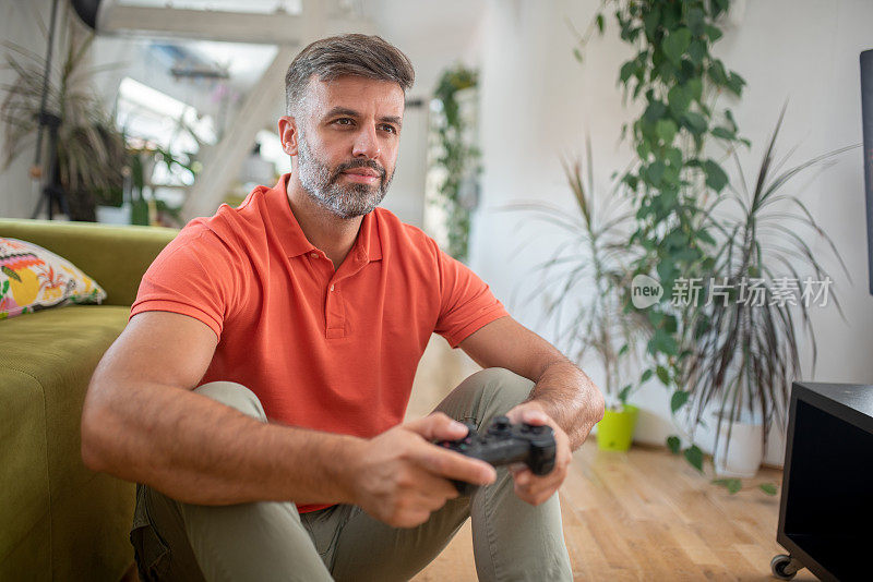 中年男子喜欢在家玩电子游戏