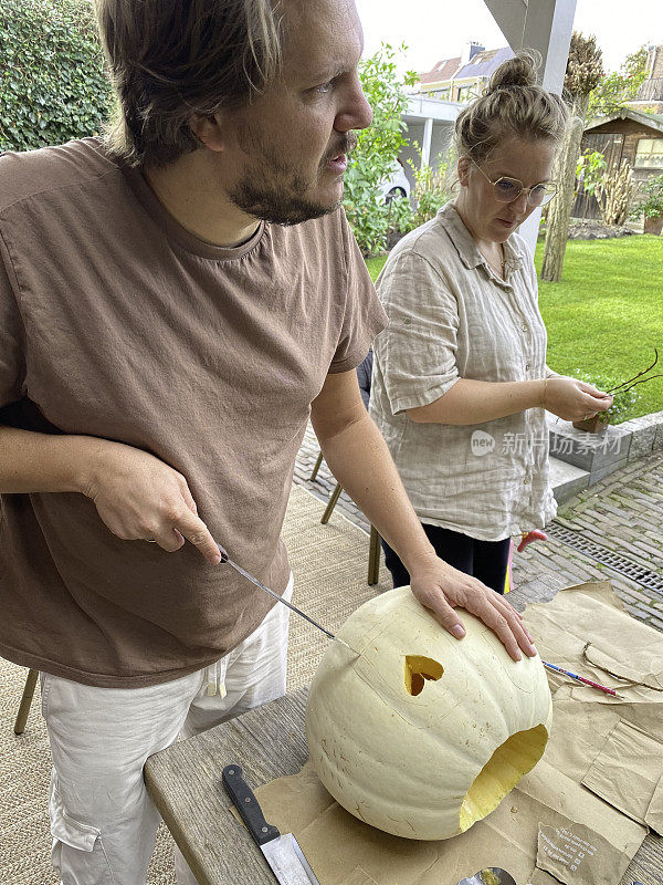年轻的家庭在制作秋天的南瓜