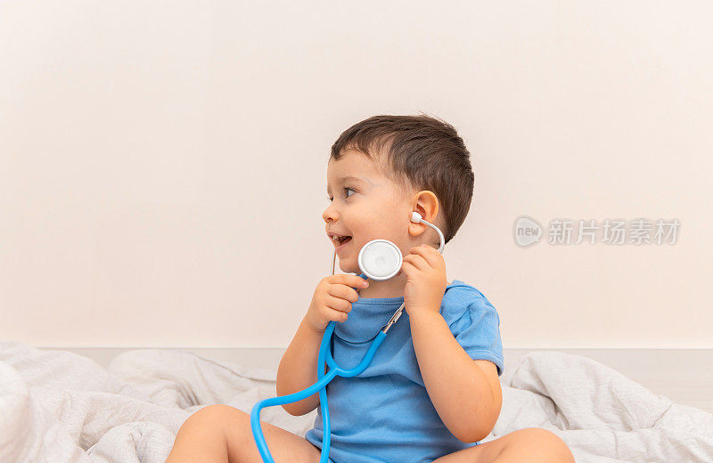 男婴戴着听诊器，扮演医生