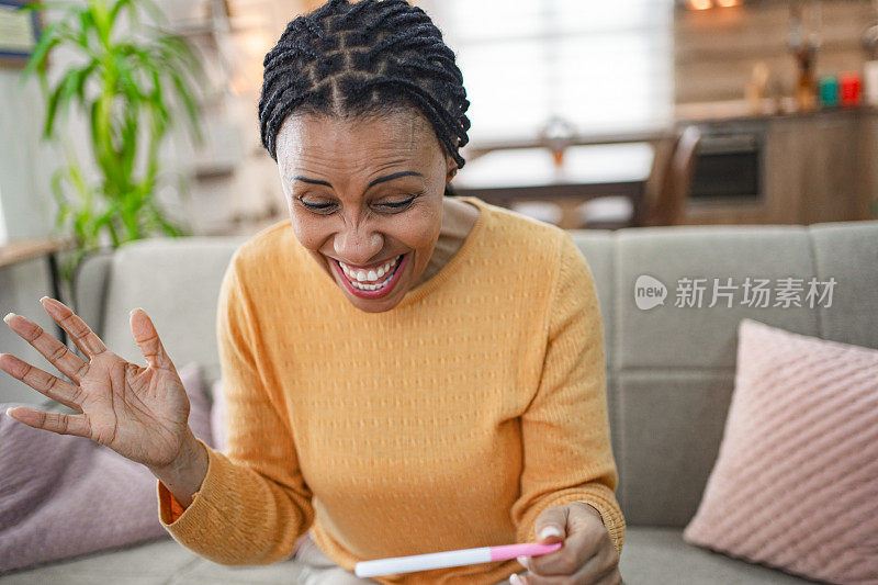 一名黑人妇女在家里得知自己的验孕结果后感到兴奋