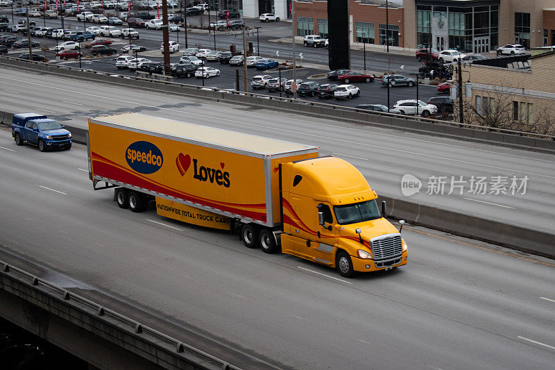 双子座汽车运输半卡车在90号州际公路上向东行驶，穿过美国华盛顿州斯波坎市的市中心。