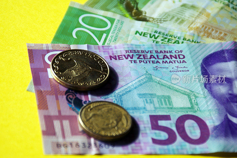 新西兰货币(NZD);彩色背景上的美元和硬币