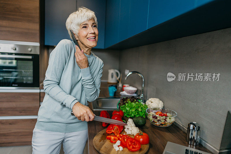 一位女士在厨房里用笔记本电脑打电话