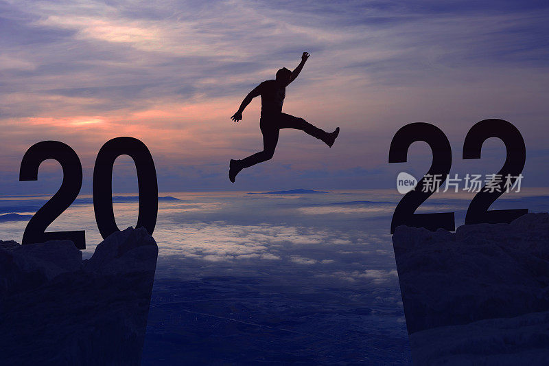 新年概念从2021年到2022年，剪影人跳跃