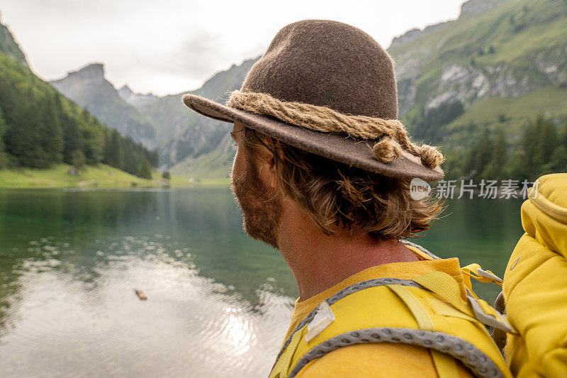活跃的男子徒步在瑞士阿尔卑斯山美丽的高山湖泊，他在散步时思考自然
