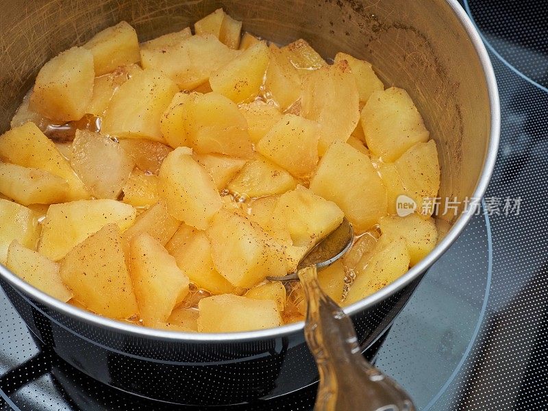 特写镜头展示了炖嘎啦苹果和肉桂的细节，这是自制节日大餐苹果酱的一部分