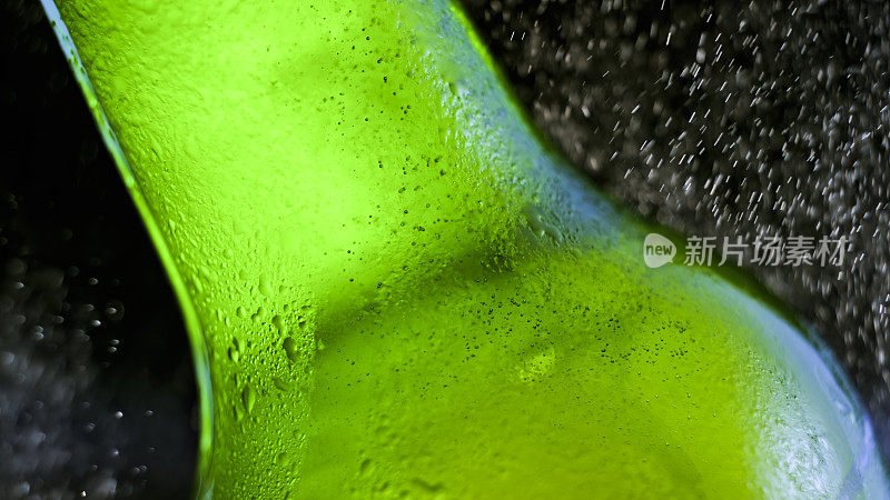 水喷在绿色啤酒瓶上