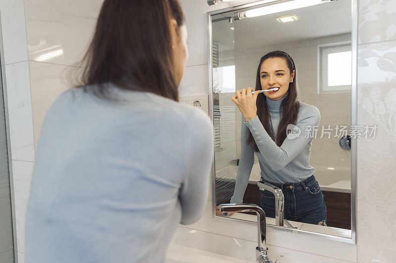 漂亮的白人女孩对着镜子刷牙