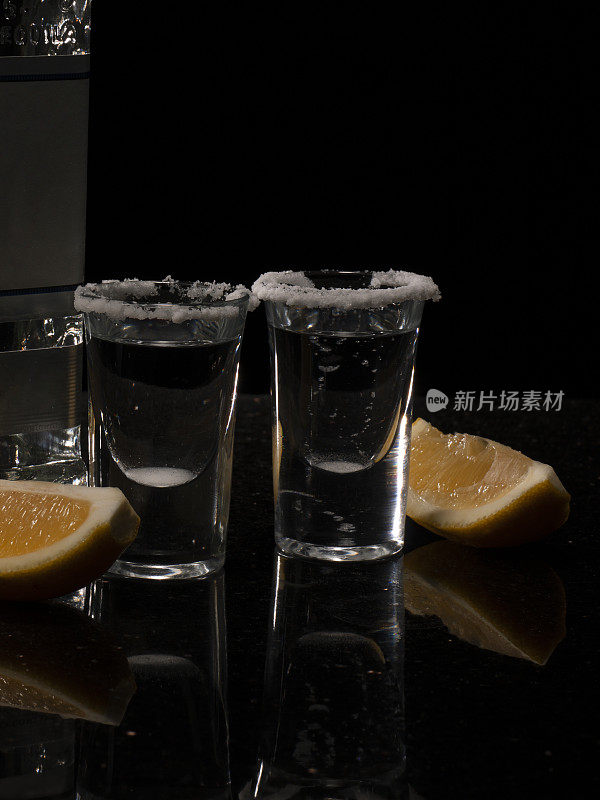 透明的龙舌兰酒酒与咸的边缘，片酸橙在优雅的玻璃杯