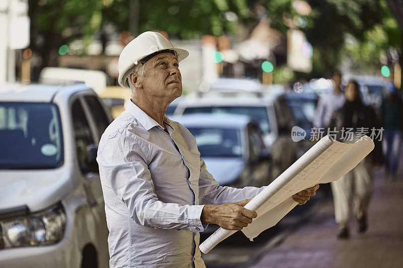 带着白色安全帽和建筑规划的建筑经理