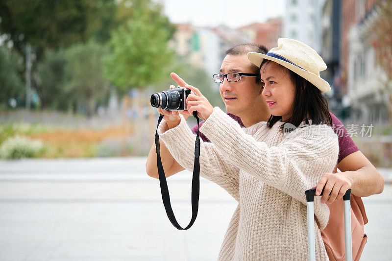 多种族情侣游客一起在城市里拍照。