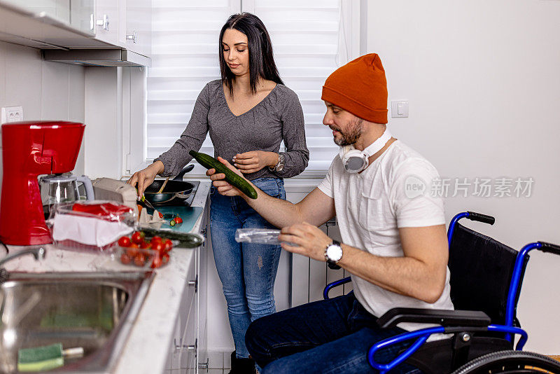 善良的年轻女子帮助轮椅上的男人做了一顿美味又营养的饭