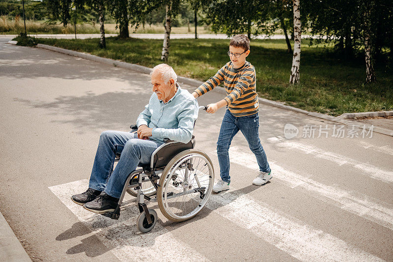 小孩在轮椅上照顾过马路的爷爷奶奶