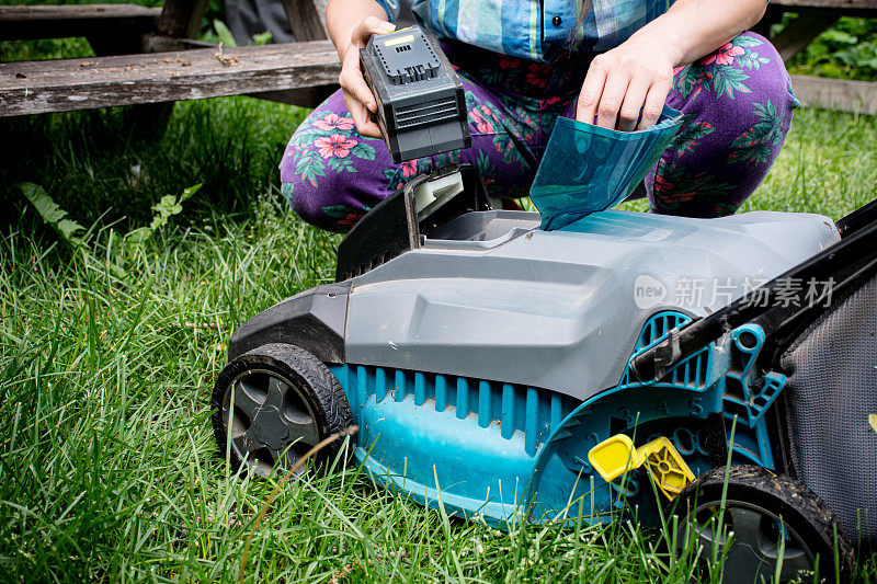 可持续能源:在加拿大的后院，被授权的妇女处理电池供电的割草机