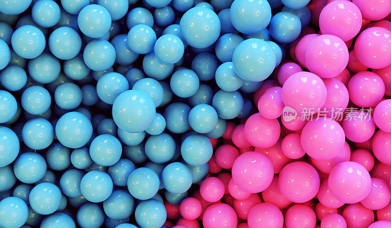 分开的粉色和蓝色的球:性别挑战的概念