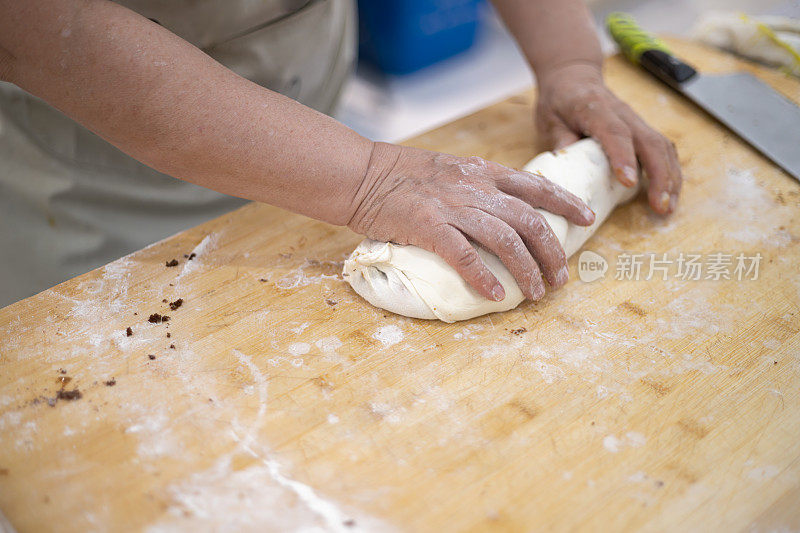 中国面食制作:中国芝麻面包。女人揉面团。制造碳水化合物食物的过程。