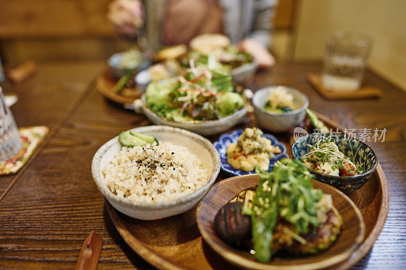 一位亚洲妇女在素食餐厅吃素食午餐。