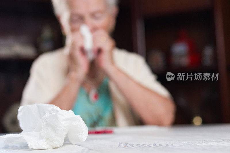 患流感的老妇人用手帕擤鼻涕