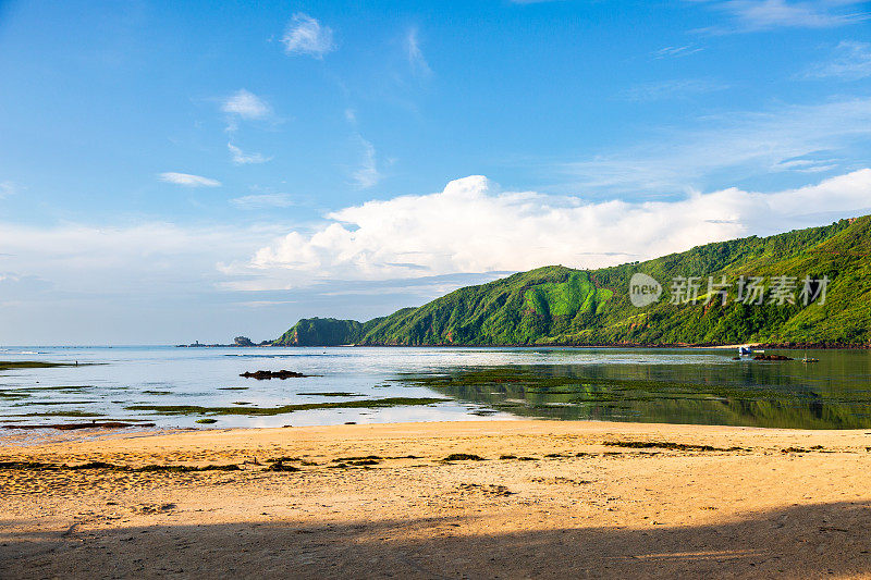 宁静的海湾在青翠的山丘:库塔海滩的全景，龙目岛。