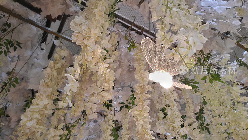 婚礼上的塑料花和发光的塑料蝴蝶装饰