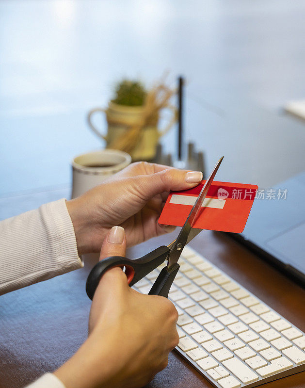 年轻女子用剪刀剪信用卡