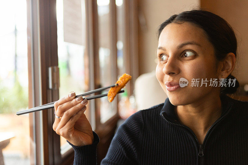 年轻女子在餐厅里吃着越南菜，配上蔬菜、鸡肉和咖喱酱米饭