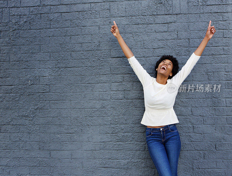 一个快活的非洲女人，双手向上举着