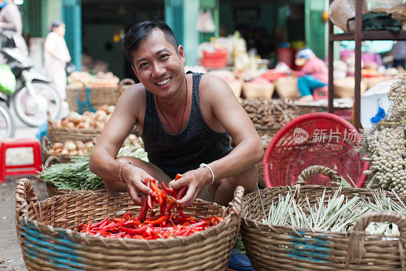 亚洲人在街头市场微笑卖红辣椒