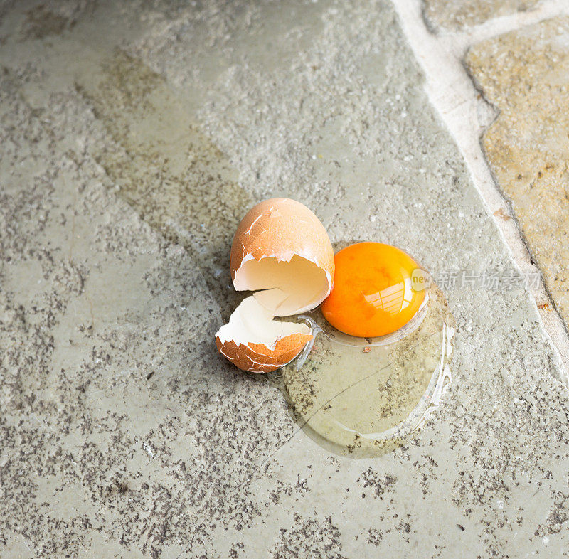碎鸡蛋掉在厨房的石头地板上
