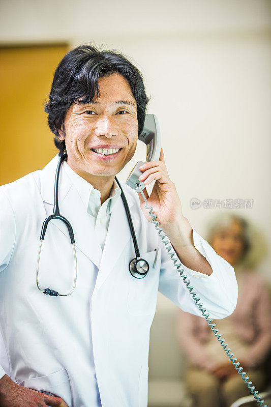 日本医生在打电话，女病人在后面