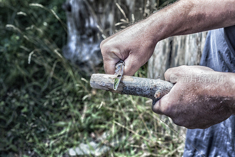 男子用削刀雕刻木棍