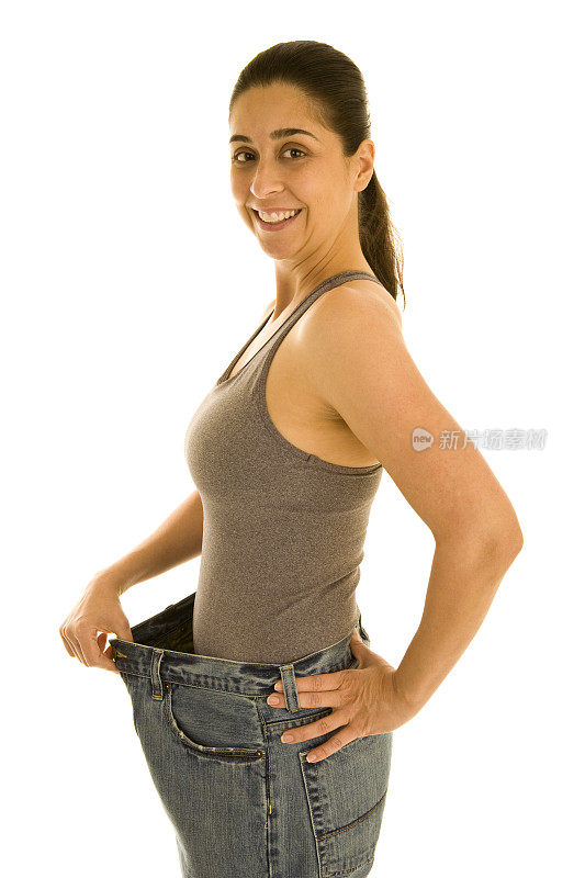 瘦女人穿着大牛仔裤显示体重减轻