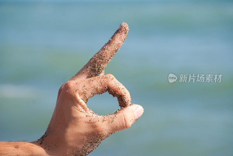 用手在沙滩上做个手势