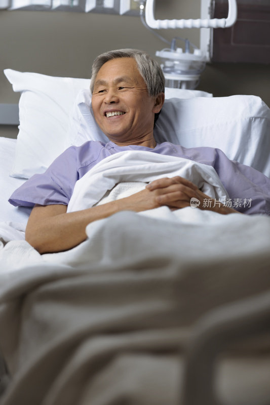 一个成熟的民族男子躺在医院的病床上