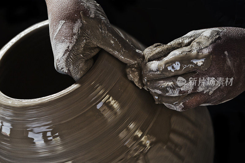 陶工泥泞的双手制作陶土