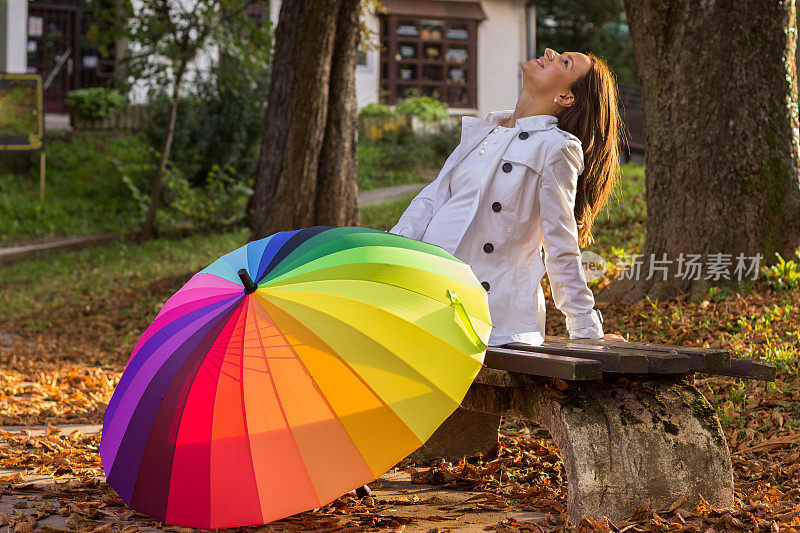 黑发女孩在森林里拿着五颜六色的雨伞