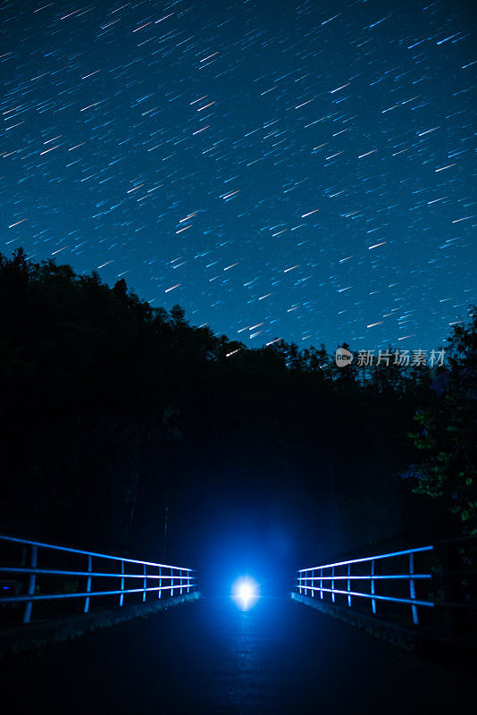 夜晚，星光在灯火通明的桥上缓缓落下