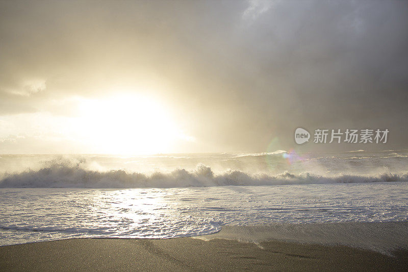 太阳从海浪和崎岖的海滩上升起