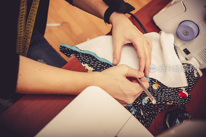 女裁缝在织物上标出裁剪线，特写