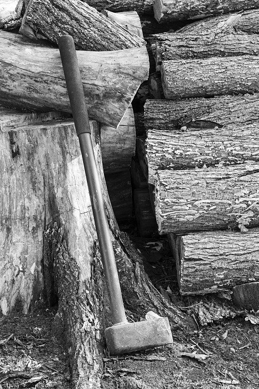 斧头放在成堆的木柴旁边