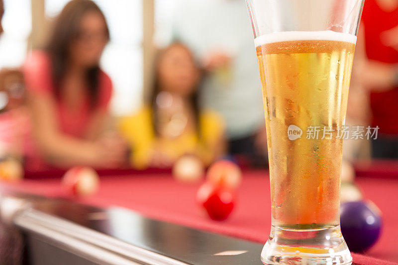 饮料:一杯冰镇啤酒坐在台球桌边。